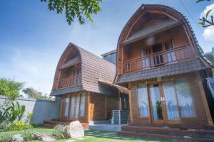 a wooden house with a gambrel roof at The Palms Canggu in Canggu