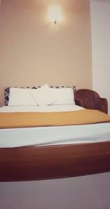 un lit avec des draps blancs et des oreillers dans une chambre dans l'établissement Thenmala Heritage, à Kollam 11 autres photos