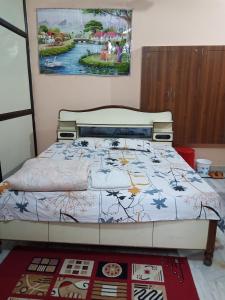 a bedroom with a bed with a painting on the wall at Sunita homestay in Agra