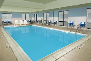 a large swimming pool with blue water in a building at Holiday Inn Express & Suites Baltimore - BWI Airport North, an IHG Hotel in Linthicum Heights