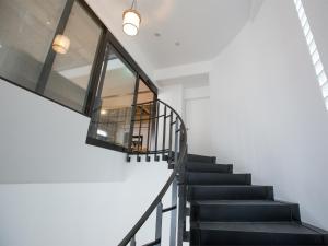 a staircase in a house with a glass wall at THE HOTELS HAKATA KASANE Bayside in Fukuoka
