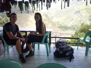 a man and a woman sitting in chairs at a table at BATAD Rita's Mount View Inn and Restaurant in Banaue