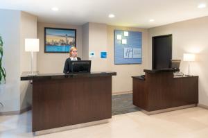 a woman is sitting at a counter in a office at Holiday Inn Express - Wall Street, an IHG Hotel in New York