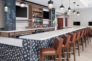 a bar with a row of chairs and a long counter at Holiday Inn Odessa by IHG in Odessa