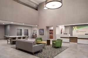 a lobby with a waiting area with chairs and a table at Holiday Inn Odessa by IHG in Odessa