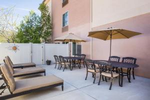 un patio con mesas, sillas y sombrillas en Holiday Inn Express Hotel & Suites Cedar City, an IHG Hotel, en Cedar City