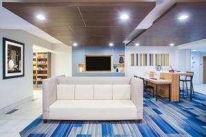 a living room with a white couch and a desk at Holiday Inn Express Hotel & Suites Cedar City by IHG in Cedar City