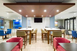 a dining room with tables and chairs and a flat screen tv at Holiday Inn Express San Jose Costa Rica Airport by IHG in Alajuela City