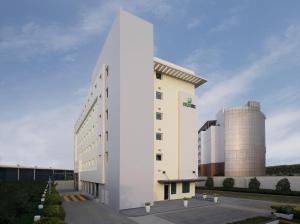 a white building next to a silo at Holiday Inn Express Bengaluru Whitefield ITPL, an IHG Hotel in Bangalore