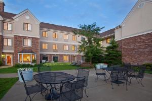 une cour avec des tables et des chaises devant un bâtiment dans l'établissement Staybridge Suites Lincolnshire, an IHG Hotel, à Lincolnshire