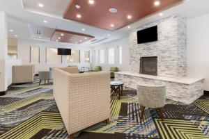 a lobby with a fireplace and chairs at Holiday Inn Express Naperville by IHG in Naperville