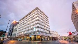 a tall building on the corner of a city street at Scenic Hotel Dunedin City in Dunedin