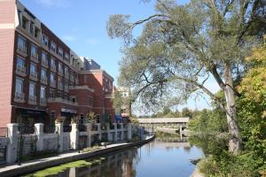 ネイパービルにあるHotel Indigo Naperville Riverwalk, an IHG Hotelの建物と橋のある都市の川