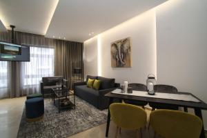 ZH Luxury Suites في سلانيك: غرفة معيشة مع أريكة وطاولة وكراسي