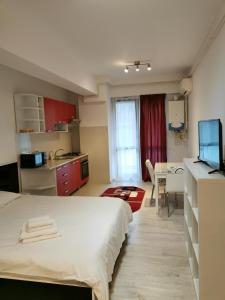a bedroom with a bed and a kitchen with a table at Center Apartments in Iaşi