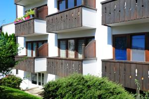 ein Apartmenthaus mit Balkonen und Fensterläden aus Holz in der Unterkunft Hindenburg str Apartments in Garmisch-Partenkirchen + 8 Fotos