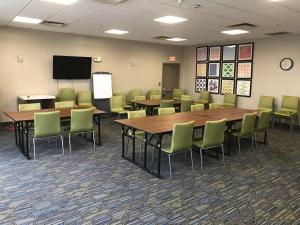 a conference room with tables and chairs and a screen at Holiday Inn Express Hotel & Suites Maryville, an IHG Hotel in Maryville