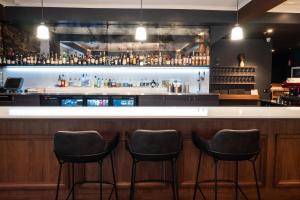 a bar with three stools in front of a counter at Peppers Cradle Mountain Lodge in Cradle Mountain