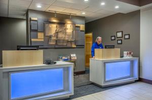 a man standing at a counter in a waiting room at Holiday Inn Express & Suites Morristown by IHG in Morristown +28 photos