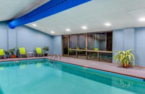 a pool in a hotel room with green chairs at Holiday Inn Express & Suites Morristown, an IHG Hotel in Morristown