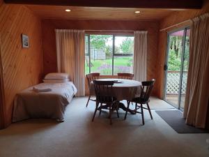 Habitación con mesa, cama y ventana en Belle Cottage en Scottsdale