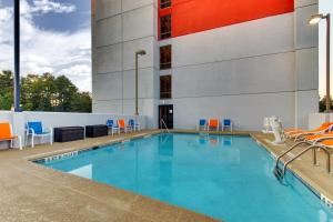 a swimming pool with chairs and a building at Holiday Inn Express & Suites Atlanta Perimeter Mall Hotel, an IHG Hotel in Sandy Springs