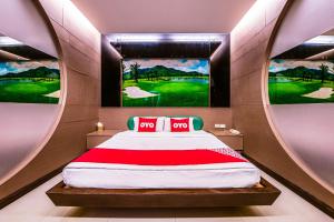een slaapkamer met een bed met 2 posters aan de muur bij OYO 502 Bangsean Hotel in Bangsaen
