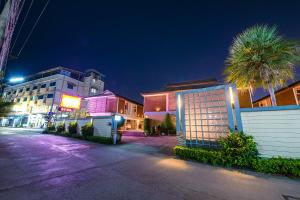 a street at night with buildings and palm trees at OYO 502 Bangsean Hotel in Bangsaen