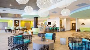 a lobby with chairs and tables and chandeliers at Holiday Inn Resort Fort Walton Beach, an IHG Hotel in Fort Walton Beach