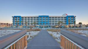 a boardwalk leading to a hotel on the beach at Holiday Inn Resort Fort Walton Beach by IHG in Fort Walton Beach