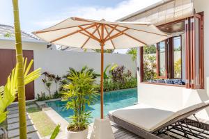 
a white umbrella sitting on top of a white table at Canang Villas Bingin in Uluwatu
