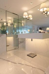 um átrio com pisos em mármore branco e paredes de vidro em Dunhua Mansion Taipei - MGallery Collection em Taipei