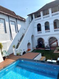 una casa con piscina al lado de un edificio en Old Courtyard Hotel, en Kochi