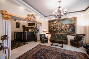 a living room with a chandelier and a painting on the wall at Hotel Royal Craiova in Craiova