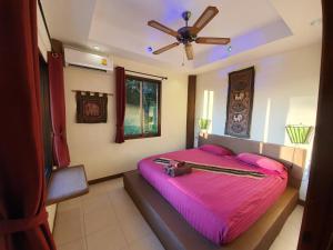 a bedroom with a pink bed with a dog laying on it at Moonstone Studio in Haad Rin