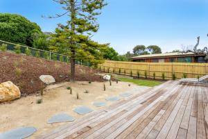 un jardín con una terraza de madera y una valla en Molly's Beach House:, en Blairgowrie