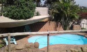 a small swimming pool with a wooden rail around it at Lothian rd Cottage in Durban