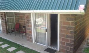 an open patio door with a blue roof at Lothian rd Cottage in Durban