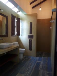 une salle de bain avec un lavabo, des toilettes et un miroir dans l'établissement villa Mosaic, à Tangalle 64 autres photos