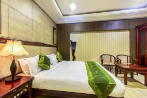 a bedroom with a bed and a table and a desk at Treebo Trend Shivani in Indore