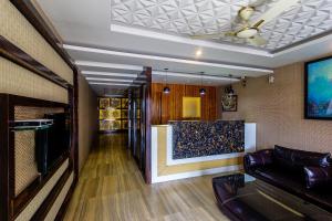 a living room with a couch and a wall at Treebo Trend Shivani in Indore