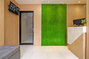 een woonkamer met een groene muur en een deur bij RedDoorz @ Mangga Besar 2 in Jakarta