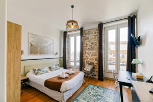 une chambre avec un lit, un bureau et des fenêtres dans l'établissement Hotel Cote Basque, à Bayonne