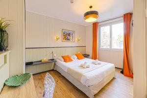 une chambre avec un grand lit blanc avec des oreillers orange dans l'établissement Hotel Cote Basque, à Bayonne
