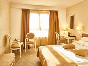 a hotel room with two beds and a table and chairs at Continental Forum Tirgu Mures in Târgu-Mureş
