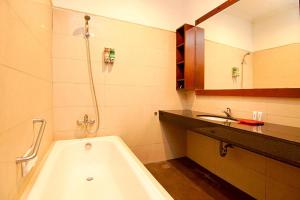 La salle de bains est pourvue d'une baignoire et d'un lavabo. dans l'établissement Kuta Paradise 777, à Legian