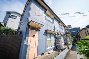 un bâtiment bleu avec une porte et une clôture dans l'établissement Nagasaki Kagamiya, à Nagasaki