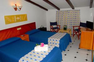 a bedroom with two beds with blue sheets and chairs at Hostal Ca'n Tiu in Alaró