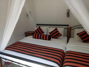 a bed with striped pillows on it in a room at White House Ella in Ella