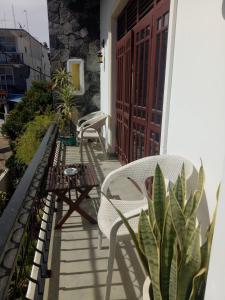 a balcony with chairs and a table and a door at White House Ella in Ella